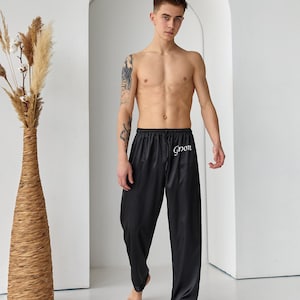 May include: Black satin pajama pants with a white "Groom" embroidery on the left leg.