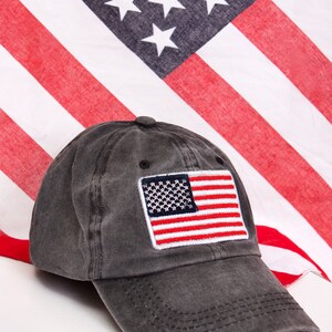 May include: A black baseball cap with a red, white, and blue American flag patch on the front.