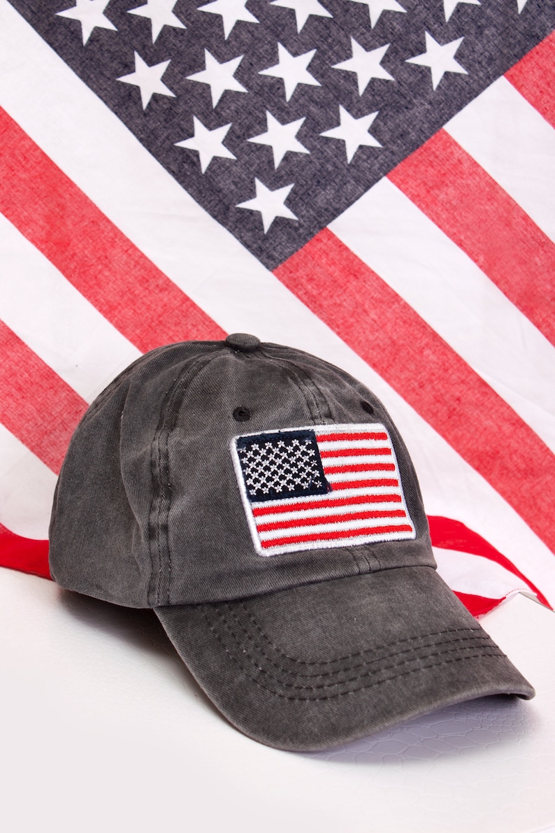 May include: A black baseball cap with a red, white, and blue American flag patch on the front.