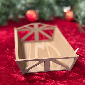 Puede incluir: Una bandeja decorativa de madera con forma rectangular y diseño de la bandera británica. La bandeja es de madera clara y tiene un fondo rojo. Probablemente se utiliza con fines decorativos.