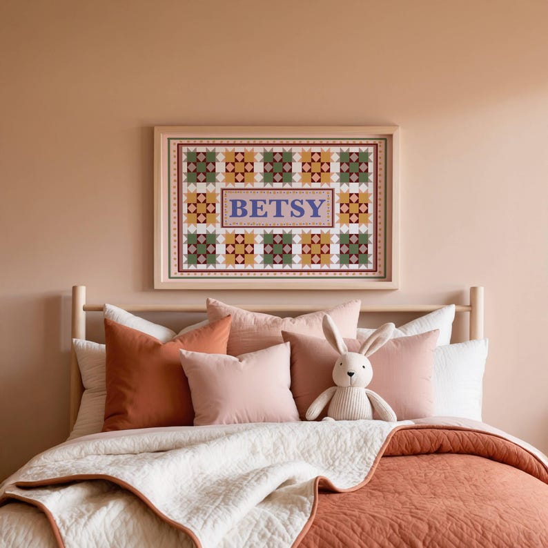 May include: A rectangular framed wall art print featuring a repeating geometric quilt-style pattern in shades of green, yellow, and white, with the name BETSY printed in large blue serif letters within a central rectangular border.