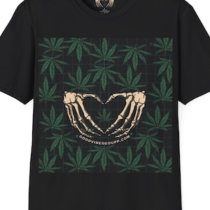 May include: Black t-shirt with a green marijuana leaf pattern and two skeleton hands forming a heart shape. The text "GOODVIBESGOUPP.COM" is printed below the hands.