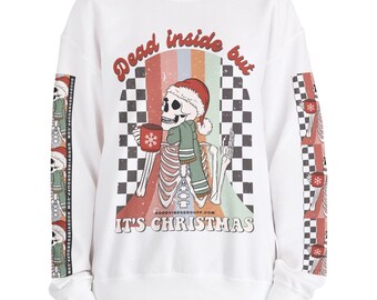 May include: White sweatshirt with a graphic of a skeleton wearing a Santa hat, holding a mug, and the text "Dead inside but it's Christmas." The sleeves have a repeating pattern of Christmas trees and skeletons.