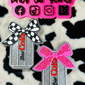 May include: Pink car air fresheners with social media icons and the text "Brit's Car Scents." Two Diet Coke can-shaped air fresheners are also visible, one with a black and white checkered bow and the other with a pink glitter bow.