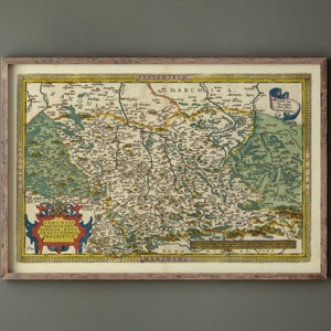 May include: A vintage map of Saxony, Germany, printed in the 16th century. The map is framed in a wooden frame and features a detailed depiction of the region's geography and cities. The map is titled "Saxoniae Miniaeque Ducatus, cum Regnis Bohemiae et Poloniae, Pars Descriptio."