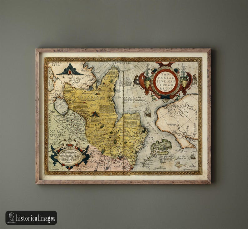May include: Framed antique map with detailed cartography, featuring a tan and yellow color palette. The map includes decorative cartouches and text, mounted in a light brown wooden frame. The map is labeled "Tartaria" and other geographical regions.