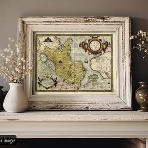 May include: Framed antique map print with a distressed white wooden frame. The map features detailed illustrations and a vintage aesthetic. The frame is rectangular and sits on a white mantelpiece, with vases and dried flowers on either side.