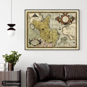 May include: A framed antique map with a black frame. The map features detailed illustrations and text in various colors, including yellow, brown, and red. The map is mounted on a white wall above a brown leather sofa. The text "historicalimages" is visible in the bottom left corner.