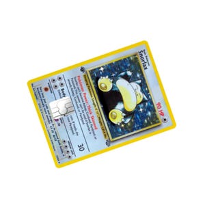 Puede incluir: Una carta coleccionable de Pok&eacute;mon con Snorlax, un Pok&eacute;mon durmiente. La tarjeta tiene un fondo azul con una imagen de Snorlax, una criatura grande, amarilla y azul. La tarjeta tambi&eacute;n incluye texto sobre las habilidades y estad&iacute;sticas del Pok&eacute;mon.