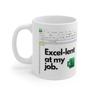 Op de afbeelding: Een witte koffiemok met een groene en witte Excel-spreadsheet afbeelding en de tekst "Excel-lent at my job."
