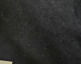 May include: A close-up of a dark grey, textured surface. The surface appears to be made of slate or a similar material.