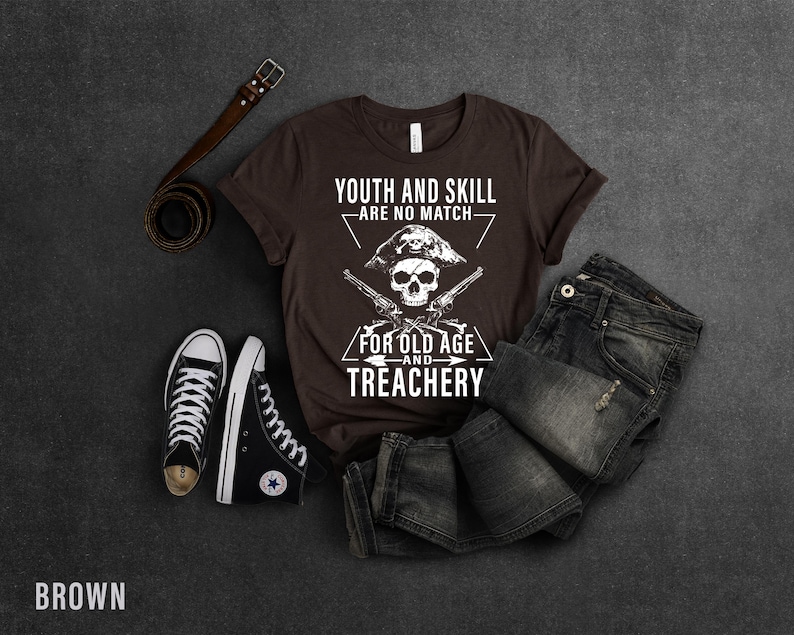 May include: Brown t-shirt with a white skull and crossbones graphic. The text reads "Youth and skill are no match for old age and treachery".