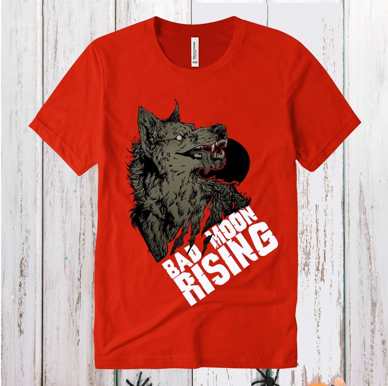 May include: Red t-shirt with a graphic of a snarling wolf with the text "Bad Moon Rising" in white.