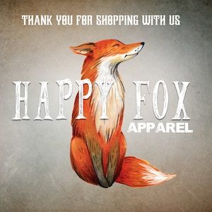 May include: A cartoon illustration of a happy orange fox with closed eyes. The text "HAPPY FOX APPAREL" is written below the fox.
