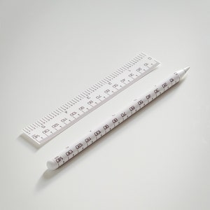 May include: Two white rulers with black markings. The smaller ruler is 15 cm long and the larger ruler is 140 cm long.