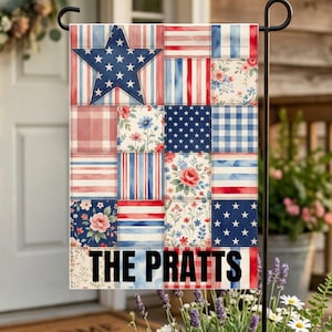 May include: A patriotic garden flag featuring a patchwork design with a large blue star and various squares with red, white, and blue patterns. The flag includes the text "THE PRATTS".