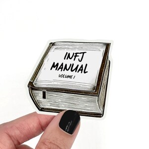 May include: A sticker of a book with the text "INFJ MANUAL VOLUME I" on the cover.