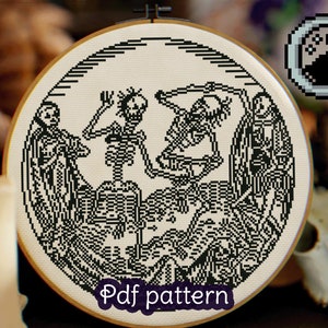 Puede incluir: Patrón de punto de cruz en blanco y negro con tres esqueletos bailando en un cementerio. El patrón está enmarcado en un aro de madera redondo e incluye el texto "Pdf pattern".