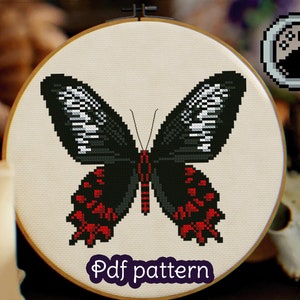 May include: Cross stitch pattern of a black butterfly with red and white accents. The butterfly is in a circular embroidery hoop. The text "Pdf pattern" is below the butterfly.