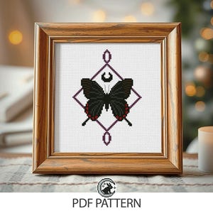 May include: A framed cross-stitch pattern featuring a black butterfly with red accents, set against a geometric purple design. The artwork is displayed in a wooden frame. The text "PDF PATTERN" is visible at the bottom.