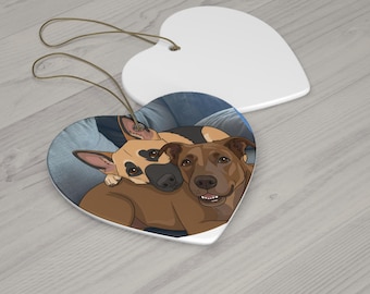 Könnte beinhalten: Zwei herzförmige Keramikornamente. Eines zeigt eine Cartoon-Illustration von zwei Hunden, einer hellbraun und schwarz, der andere braun. Das andere ist schlicht weiß. Beide haben braune Schnuraufhänger.