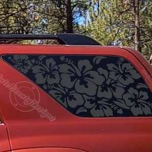 May include: A red SUV with a black window decal of gray hibiscus flowers. The decal is on the back passenger window and says "Auto Beauty Designs" on the side of the vehicle.