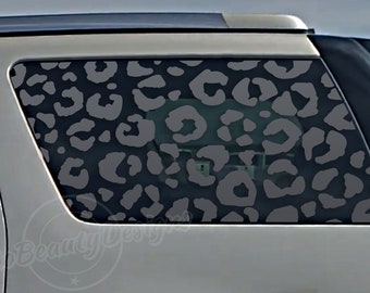 May include: A gray and black leopard print car window decal. The decal is applied to the back window of a silver SUV.