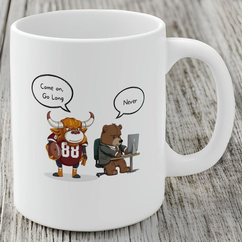 May include: White ceramic coffee mug with a cartoon bull wearing a football jersey and a cartoon bear wearing a suit and looking at a computer. The bull has a speech bubble that says "Come on, Go Long" and the bear has a speech bubble that says "Never".