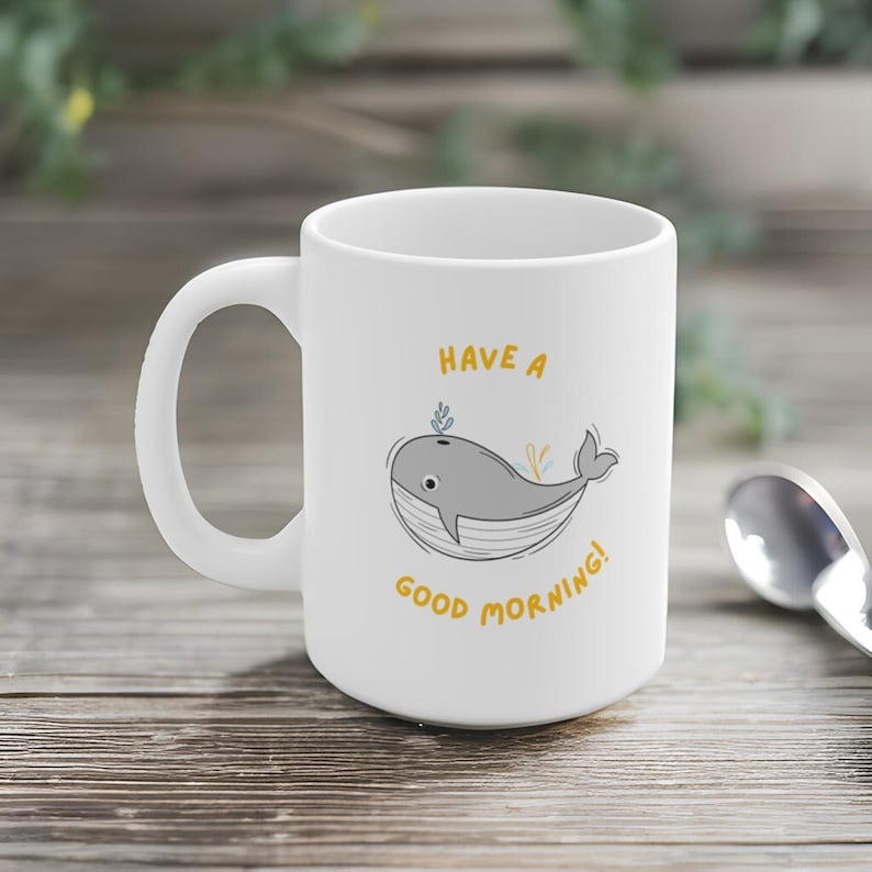 May include: White ceramic mug with a gray whale illustration and the text "Have a good morning!" in yellow.