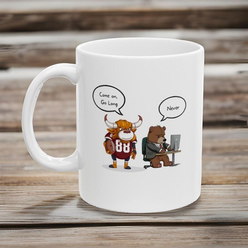 May include: White ceramic coffee mug with a cartoon bull wearing a football jersey and a bear wearing a suit and looking at a computer. The bull has a speech bubble that says "Come on, Go Long" and the bear has a speech bubble that says "Never".