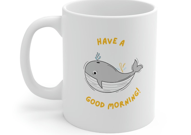 May include: White ceramic coffee mug with a cartoon whale illustration and the text "Have a good morning!" in yellow.