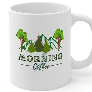 May include: White ceramic mug with a green mountain scene and trees. The text "Morning Coffee" is printed on the mug.