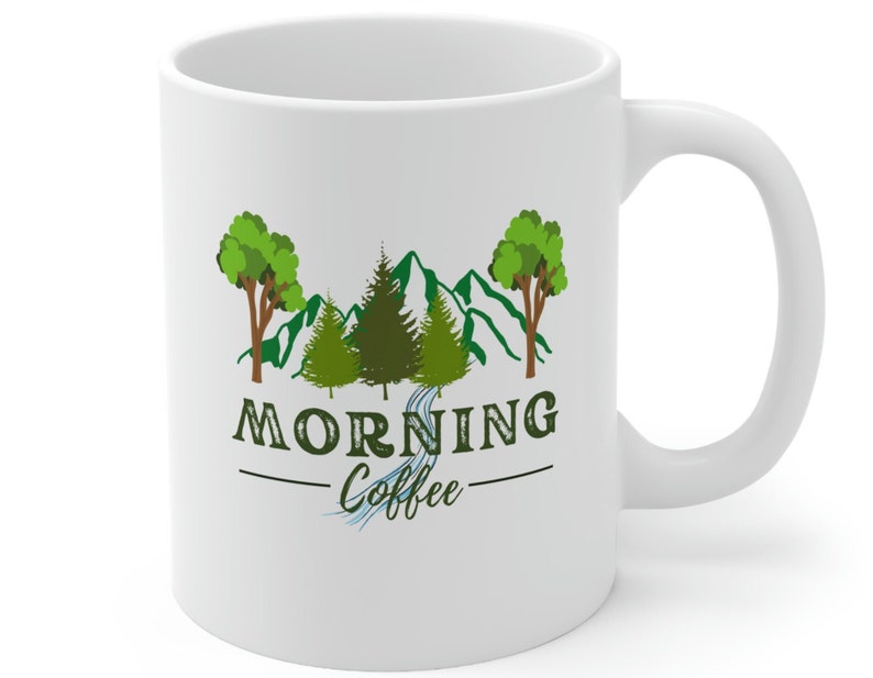 May include: White ceramic mug with a green mountain scene and trees. The text "Morning Coffee" is printed on the mug.
