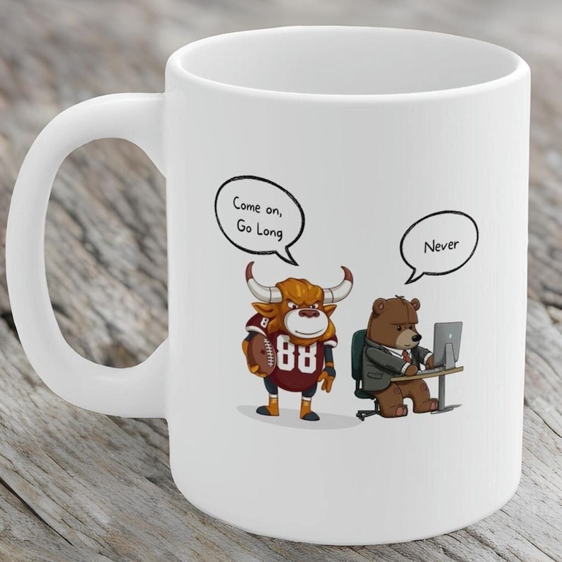 May include: White ceramic coffee mug with a cartoon bull wearing a football jersey and holding a football. The bull is saying "Come on, Go Long". A cartoon bear wearing a suit and tie is sitting at a desk with a computer and saying "Never".