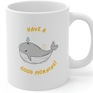 May include: White ceramic coffee mug with a gray whale illustration and the text "Have a good morning!" in yellow.