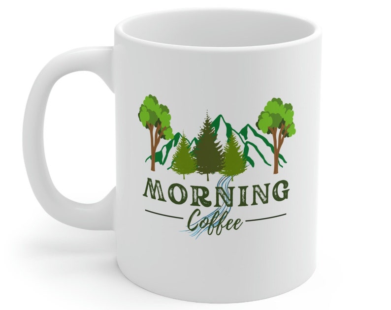 May include: White ceramic mug with a green mountain scene and trees. The text "Morning Coffee" is printed on the mug.