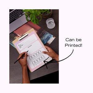 May include: A printable nail art chart with a pink background and black outlines of nails. The chart is on a clipboard and a person is writing on it with a pencil.