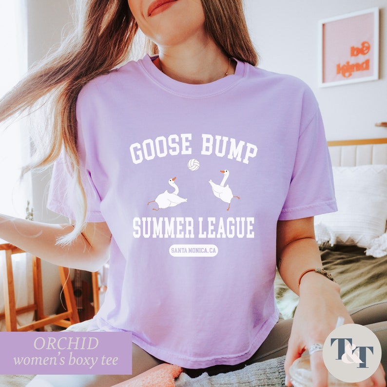 a woman sitting on a bed wearing a goose bump t - shirt