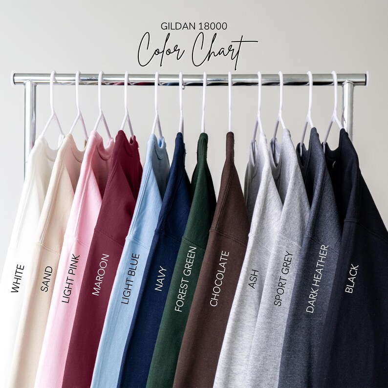 Puede incluir: Una carta de colores de sudaderas Gildan 18000 en varios colores, incluyendo blanco, arena, rosa claro, granate, azul claro, marino, verde bosque, chocolate, ceniza, gris deportivo, gris oscuro jaspeado y negro. Se muestra el texto "Color Chart".