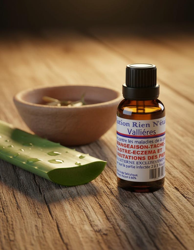May include: A brown glass bottle with a black cap and white label, next to a wooden bowl and a green aloe vera leaf on a wooden surface. The label has text in French. The bottle is approximately 3 inches tall.