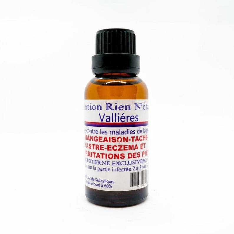 May include: A brown glass bottle with a black cap and a white label. The label has text in French, including "otion Rien N'&eacute;t Valli&eacute;res" and other descriptive text. The bottle is on a white background.