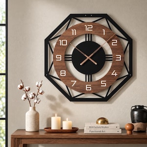 May include: A wall clock featuring a black octagonal metal frame surrounding a circular wood-grain face. The clock has a solid black center, white Arabic numerals, and thin copper-colored hands. The design includes vertical black bars.