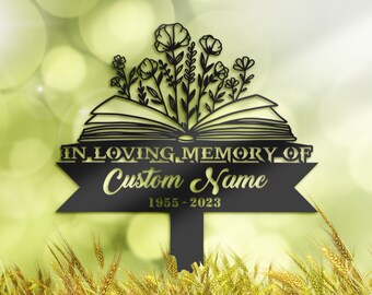 May include: Black metal garden stake with an open book design and flowers growing from the pages. The stake has a banner that reads "In Loving Memory of Custom Name 1955-2023".
