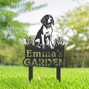 May include: Black metal garden stake with a silhouette of a beagle dog sitting on a bed of grass. The stake has the text "Emma's Garden" on it.