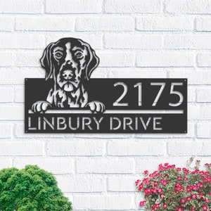 Może przedstawiać: Czarny metalowy znak z numerem domu, z sylwetką psa wystającą z góry. Znak zawiera napis "2175 Linbury Drive".