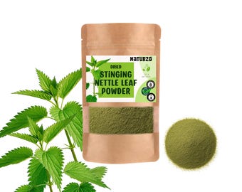 Può includere: Una confezione di carta marrone di polvere di foglie di ortica essiccate, con un mucchio di polvere verde e foglie fresche di ortica. La confezione ha un'etichetta verde e bianca con il marchio "Naturzo". Il prodotto è etichettato come 100% naturale.