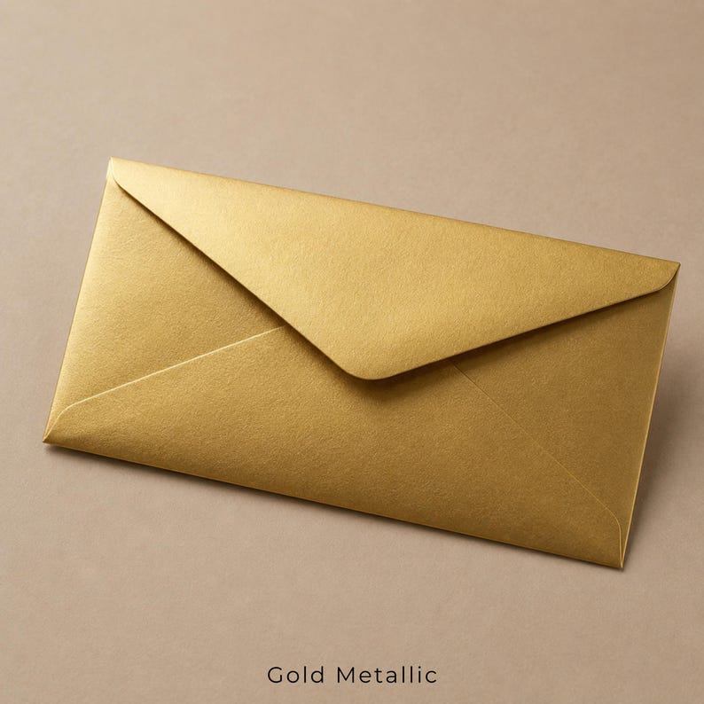 Op de afbeelding: Een rechthoekige envelop met een metallic gouden afwerking en een puntige klep. De envelop heeft een glad, reflecterend oppervlak dat het licht opvangt, waardoor subtiele variaties in de gouden tint over de gevouwen papierstructuur ontstaan.