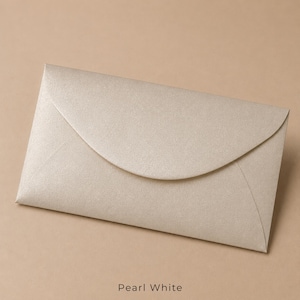 Op de afbeelding: Een rechthoekige envelop met een gebogen klep in een glinsterende parelwitte afwerking. Het papier heeft een subtiele metallic textuur die het licht over het oppervlak weerkaatst. De tekst Pearl White staat onderaan in een zwart lettertype.