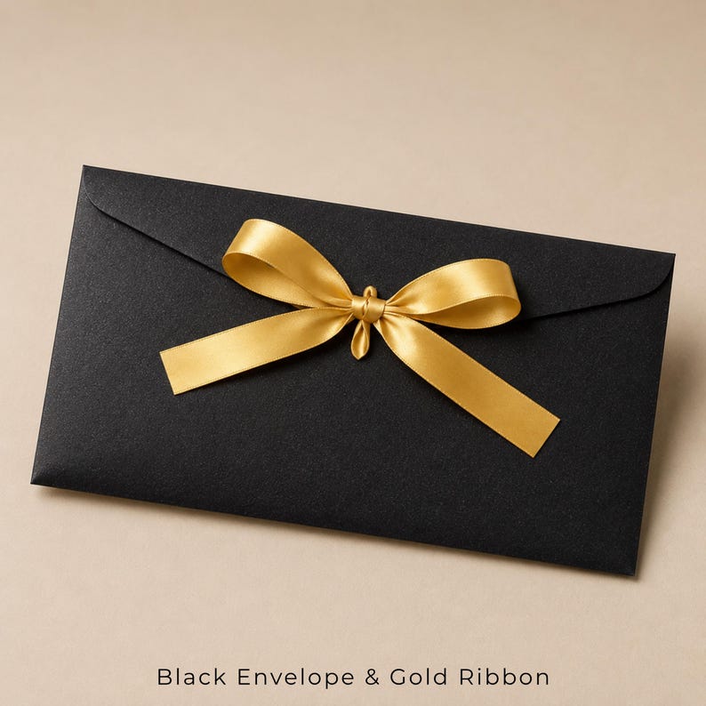 Op de afbeelding: Een rechthoekige zwarte envelop met een centraal gestrikte gouden lintstrik. De envelop heeft een gladde, matte textuur en een puntige klep. De tekst "Black Envelope & Gold Ribbon" is in het zwart onderaan de afbeelding gedrukt.
