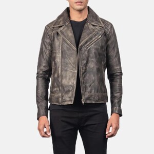 Puede incluir: Chaqueta de cuero marrón desgastado con un estilo motero clásico. La chaqueta presenta un cuello con muescas, detalles acolchados en los hombros y cierre de cremallera frontal. La chaqueta tiene un aspecto desgastado y vintage.